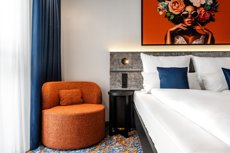 Modernes Hotelzimmer im Aiden by Best Western Velbert mit orangefarbenem Sessel