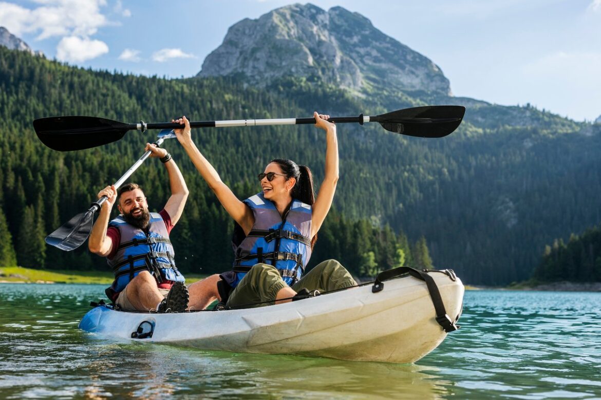 Personen beim Kajakfahren auf einem See als aktive Reiseidee