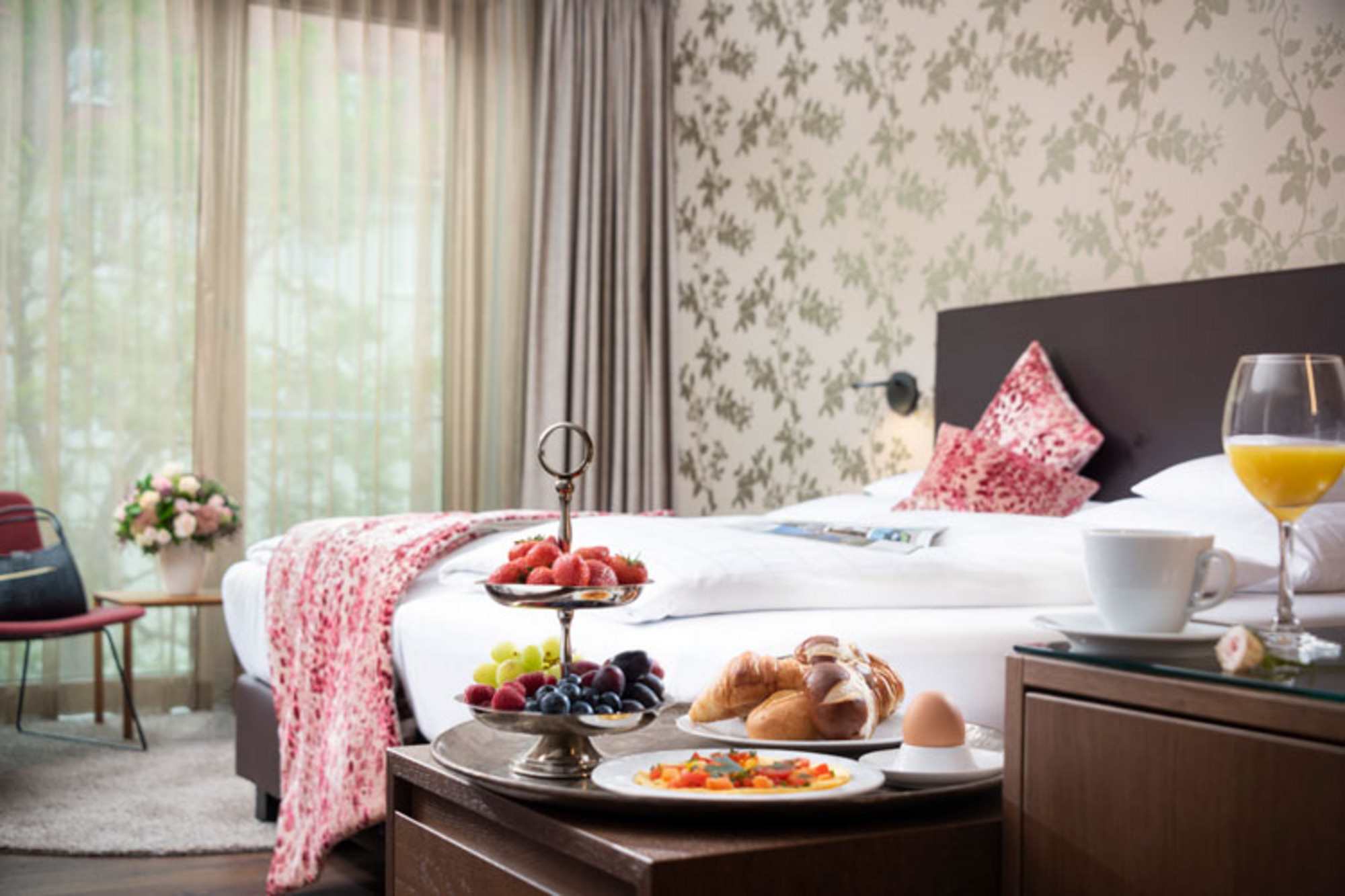 Frühstück mit Croissant, Ei und Orangensaft auf einem Hotelzimmer