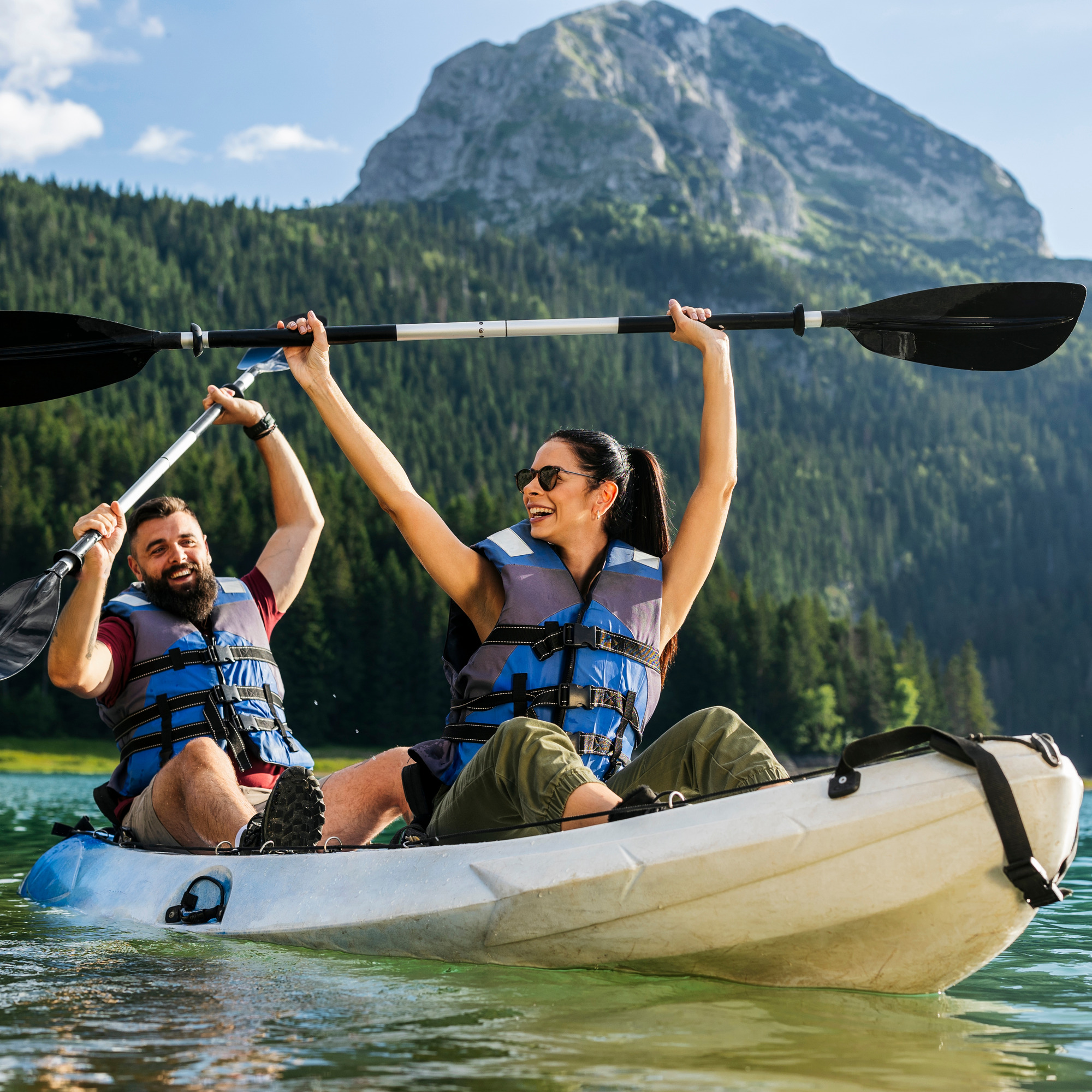 Zwei Menschen beim Kajakfahren auf einem Bergsee
