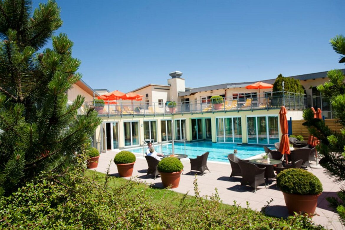 Modernes Wellnesshotel mit Außenpool, Terrasse und Sonnenschirmen