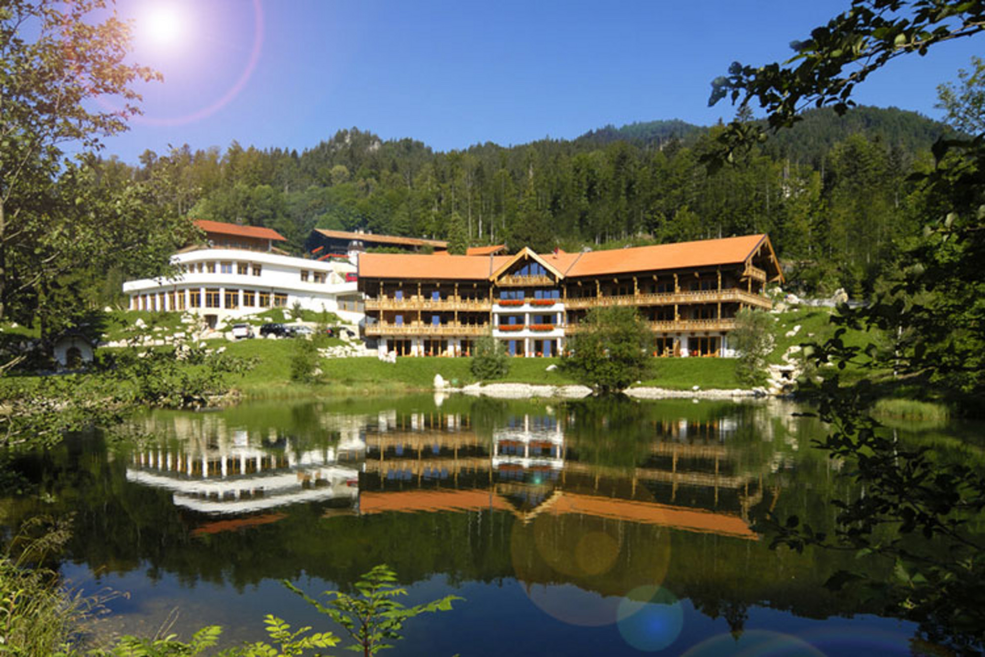Hotelanlage am See mit Holzgebäuden und Wald