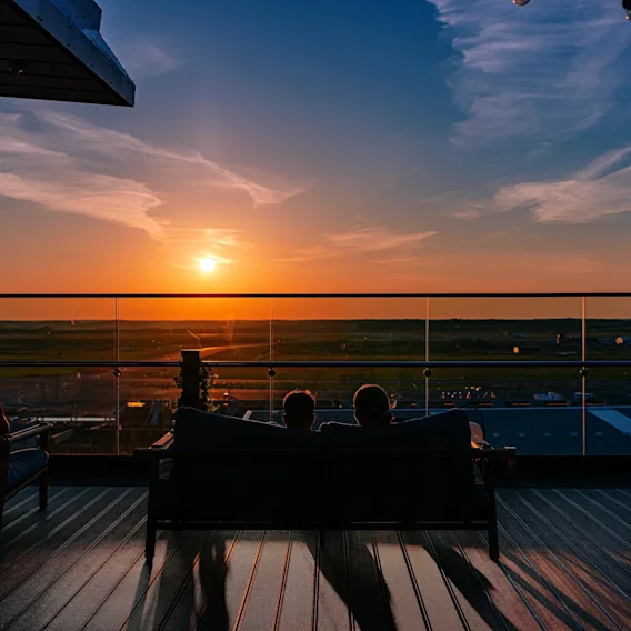 Menschen auf einer Dachterrasse bei Sonnenuntergang