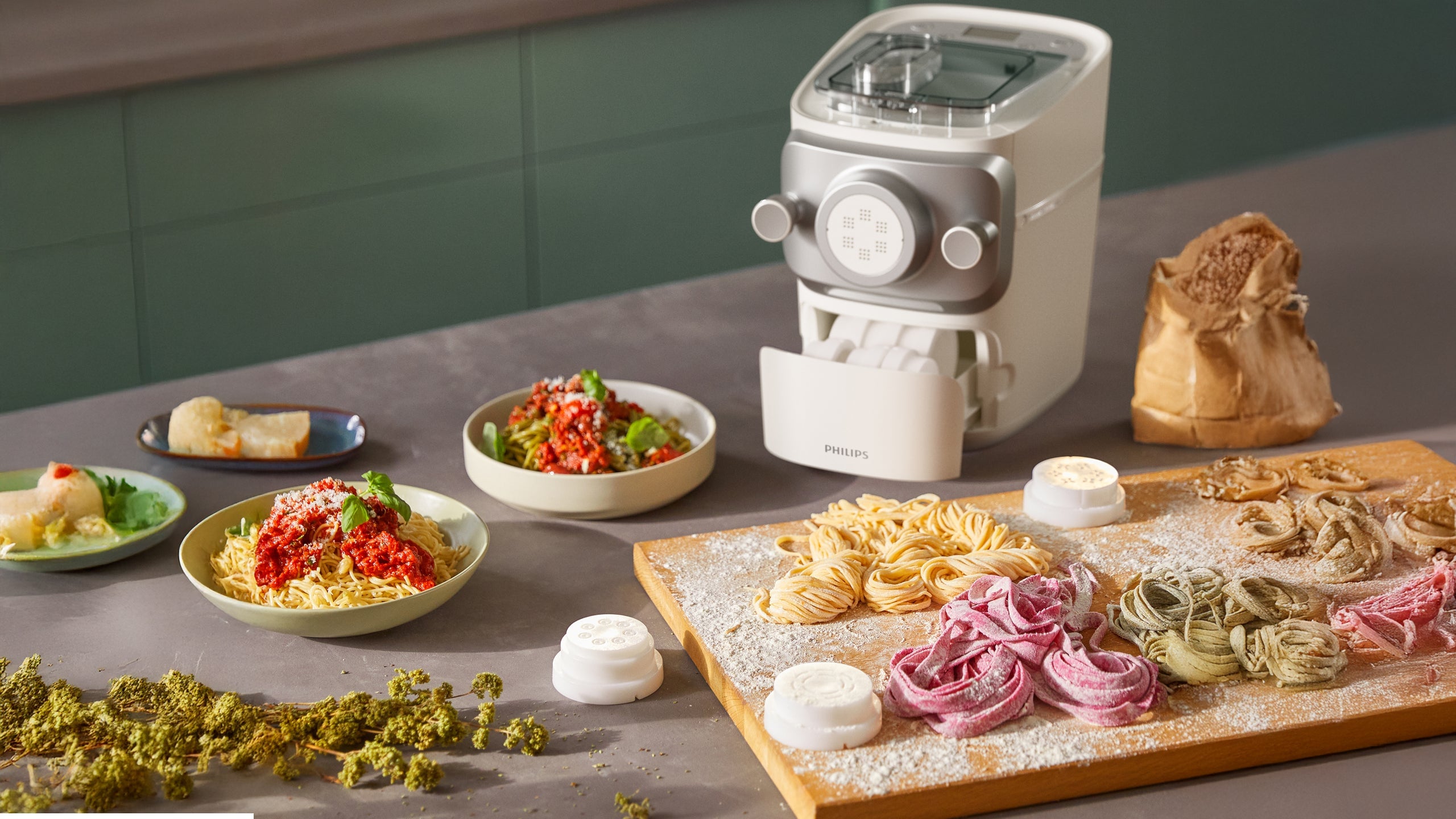 Philips pasta maker with several shapes of fresh pasta on a table