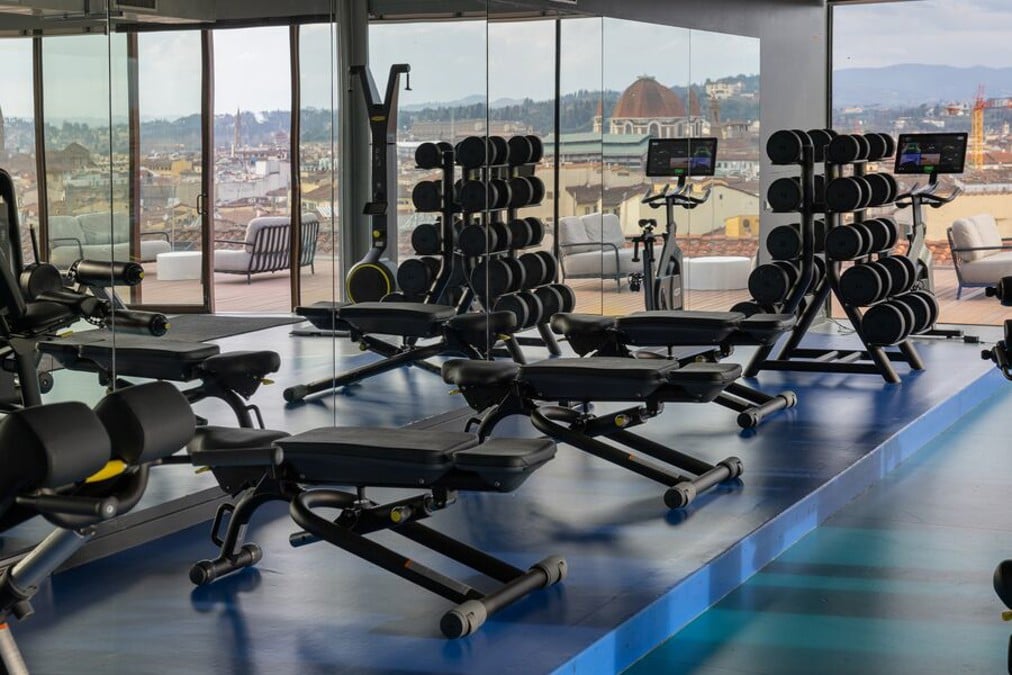 Gimnasio moderno de The Social Hub con máquinas y vistas urbanas
