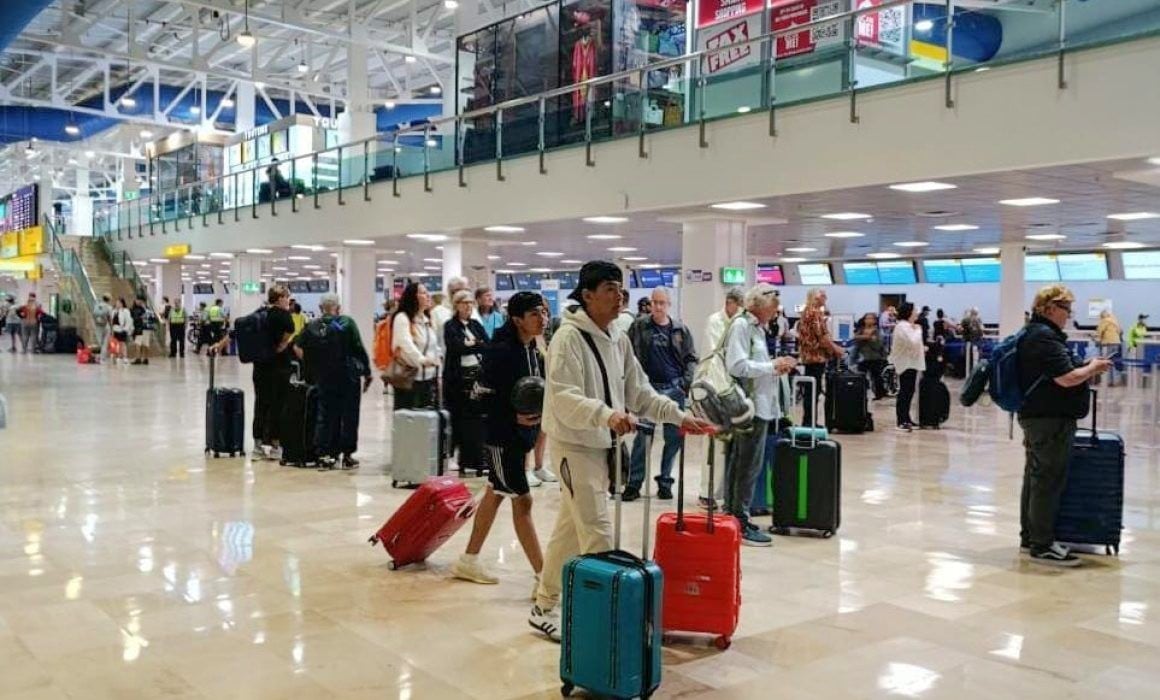 Travellers moving through a bright airport terminal
