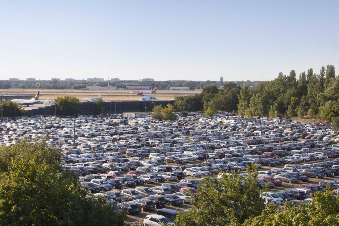 Cars parked along a city street near a travel destination
