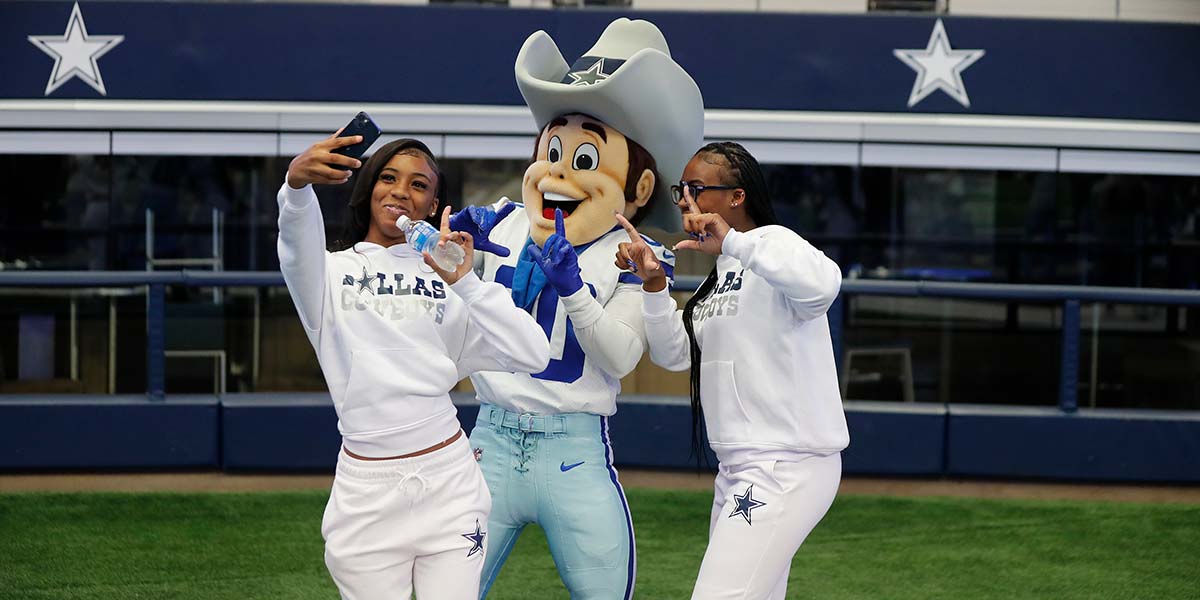 Fans taking a selfie with the Dallas Cowboys mascot inside AT&T Stadium