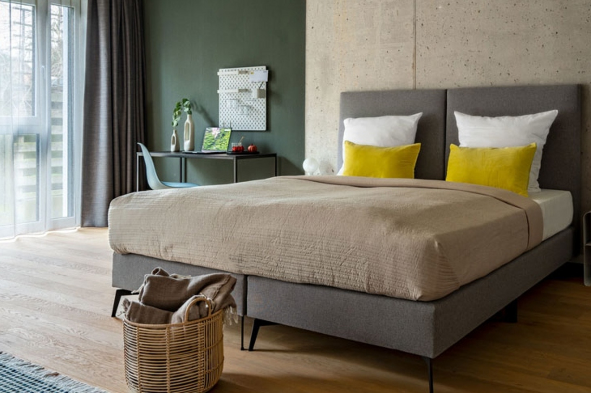 Modernes Hotelzimmer mit Doppelbett und großen Fenstern