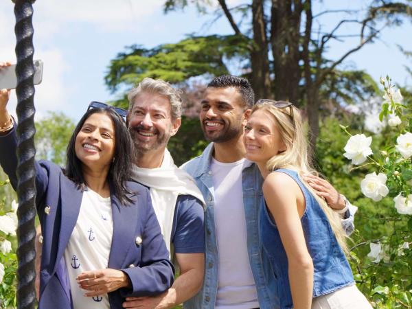 Visitors taking a selfie beside white roses in the Rose Garden at Blenheim Palace