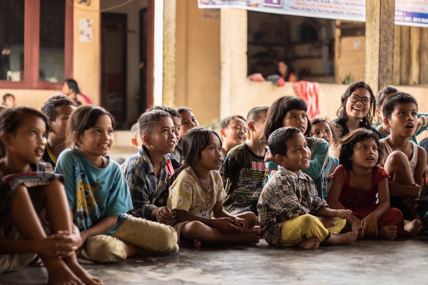 Children seated indoors watching an activity