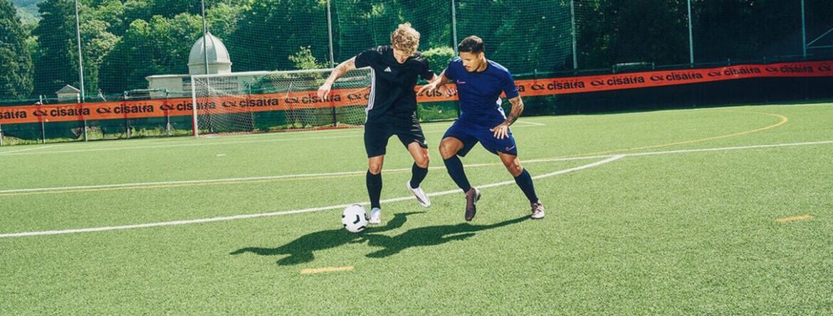 Due calciatori in azione su un campo all'aperto