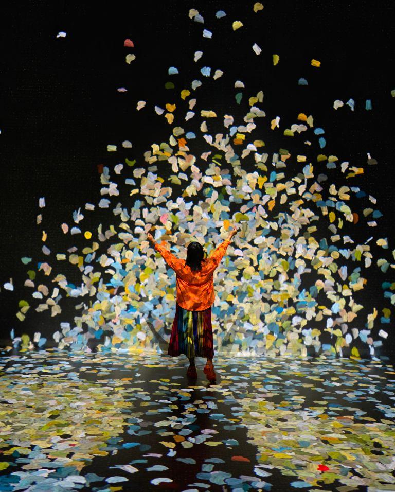 A visitor raising their hands inside the Colour in Motion gallery