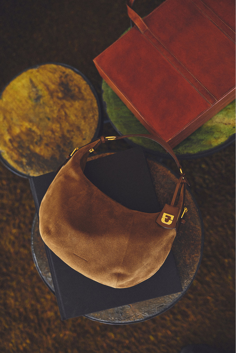 Sac Luna Gerard Darel en cuir velours camel posé sur une table