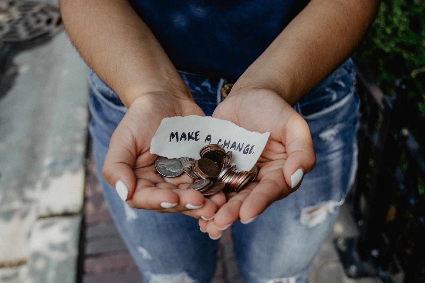 Hands holding coins and a handwritten note