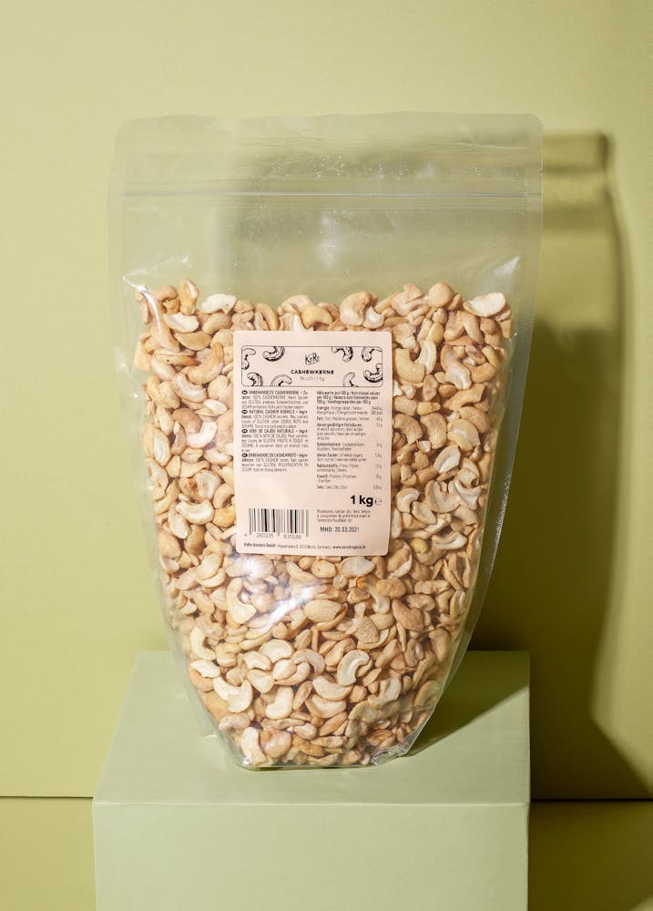Beutel Cashewbruch 1 kg auf einem grünen Podest