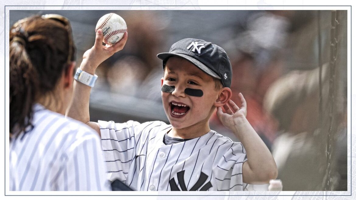 Young Yankees fan in a pinstriped jersey holding a baseball