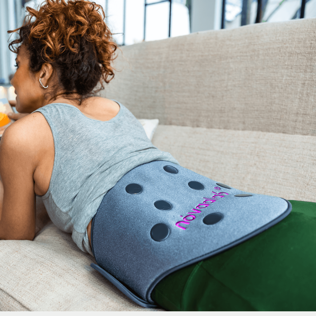 Woman reclining with a NOVAALAB LLC Back Pad on her lower back