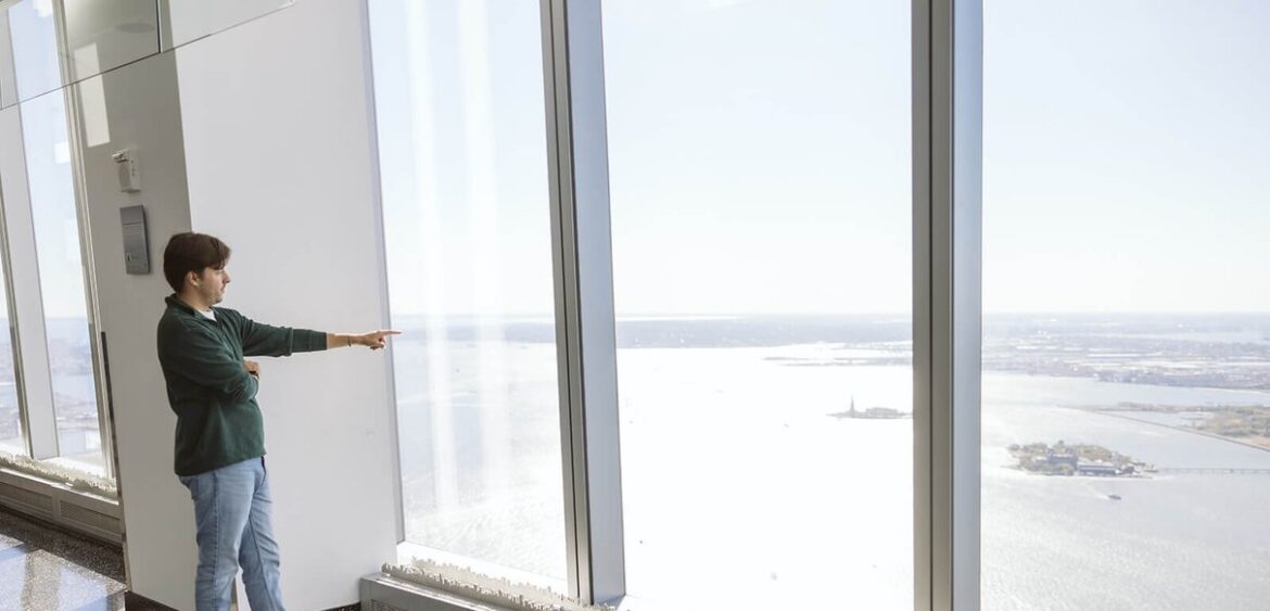 Visitors looking across the New York skyline from One World Observatory