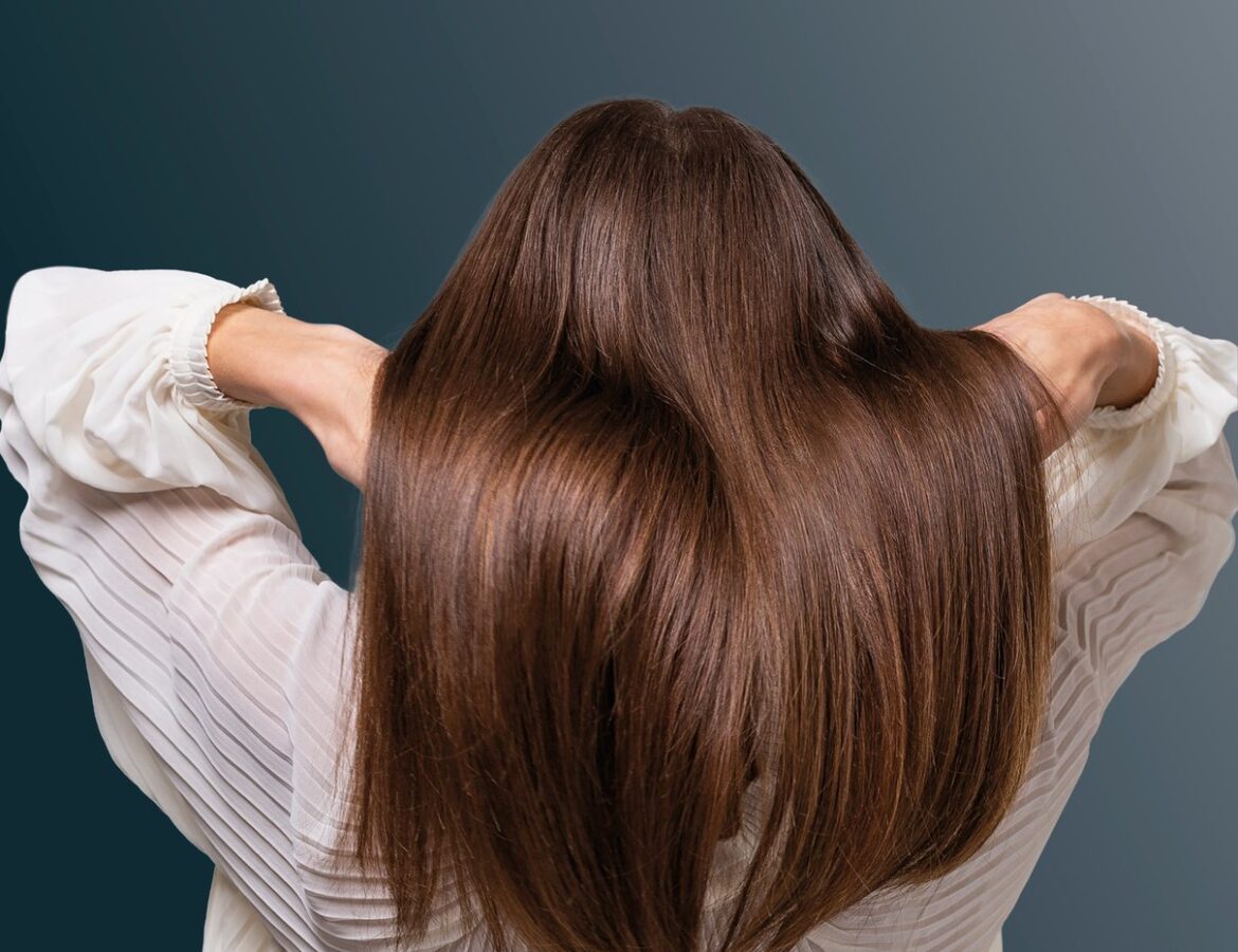 Mujer mostrando su cabello largo en una escena de cuidado personal
