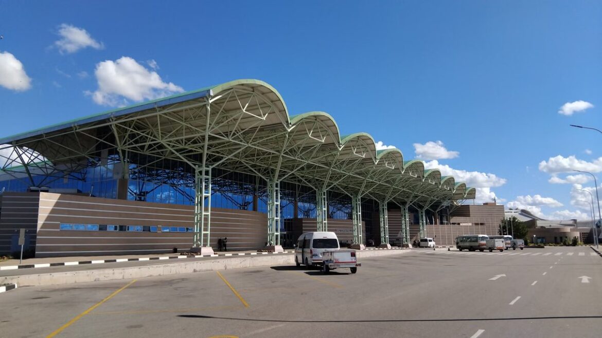 Vehicles waiting outside a modern airport terminal