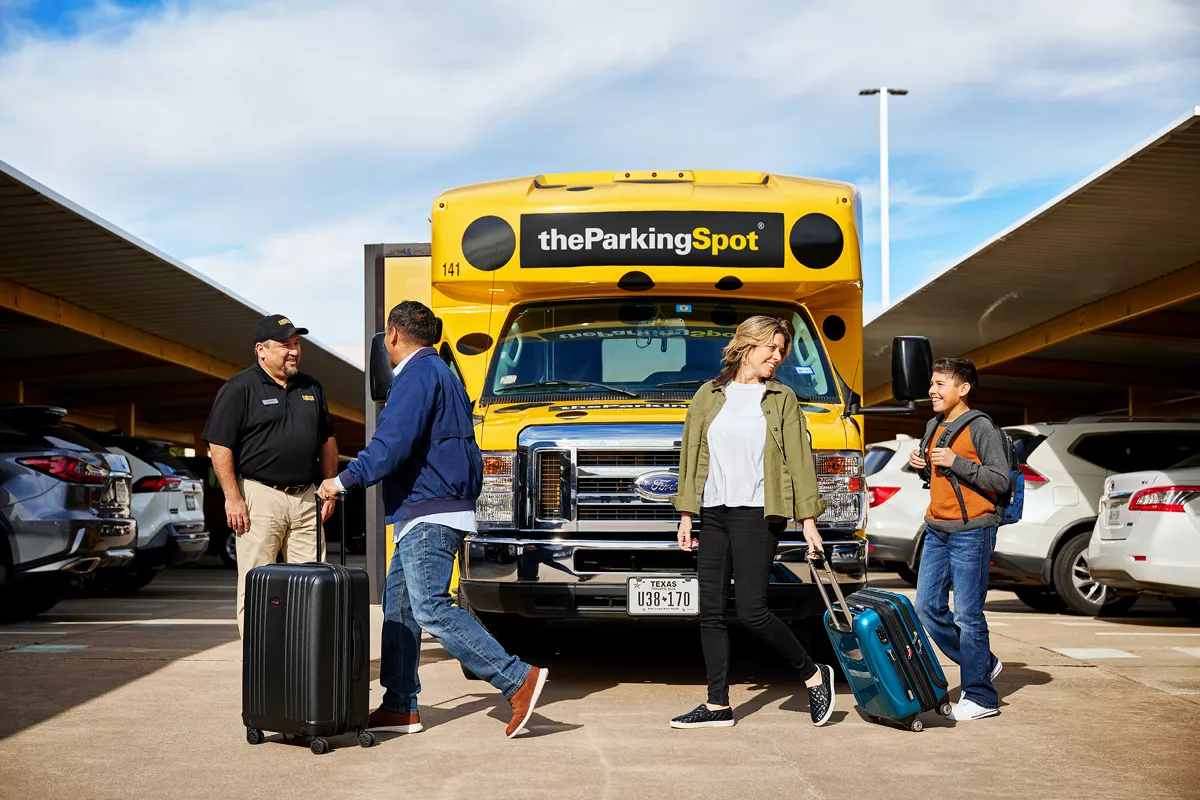 Family approaching an airport parking shuttle bus