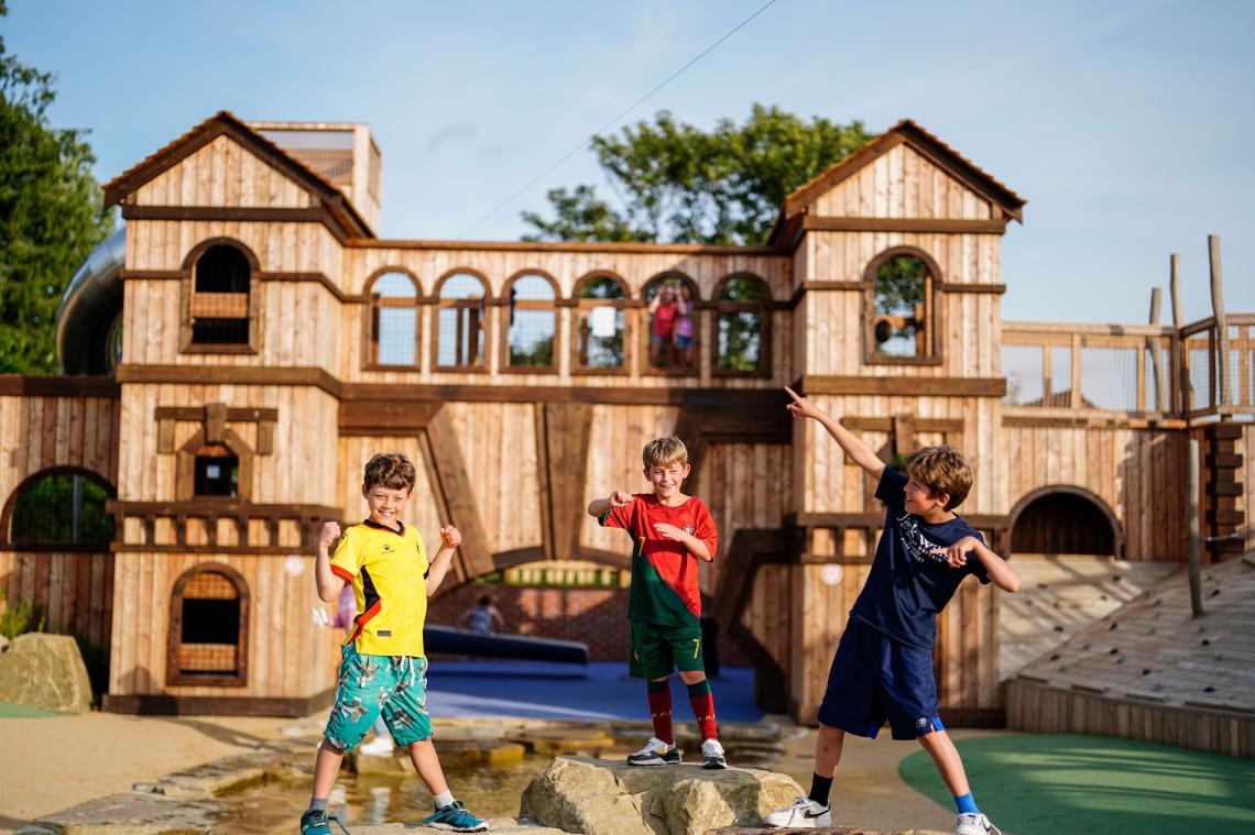 Children playing on a wooden fort in the Adventure Play area