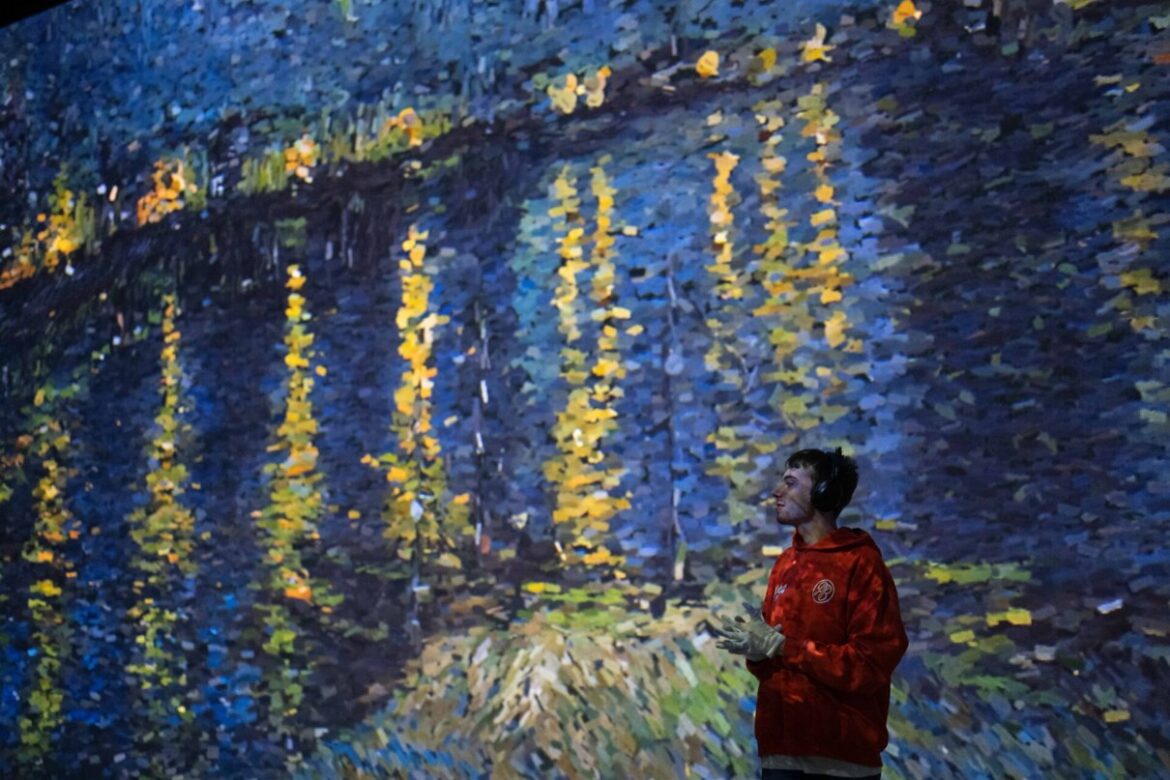 Visitors surrounded by projected Van Gogh artwork in a Frameless gallery