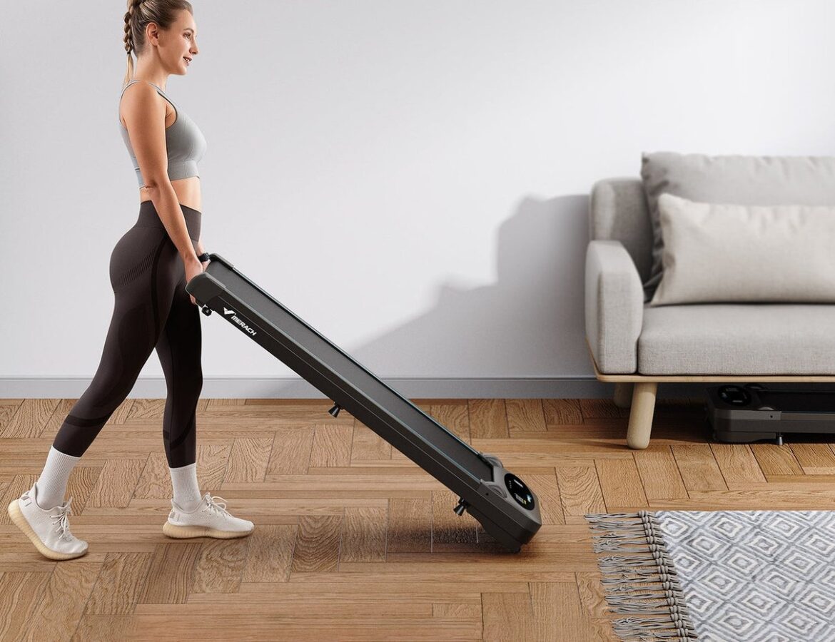 Woman moving a Merach folding treadmill at home