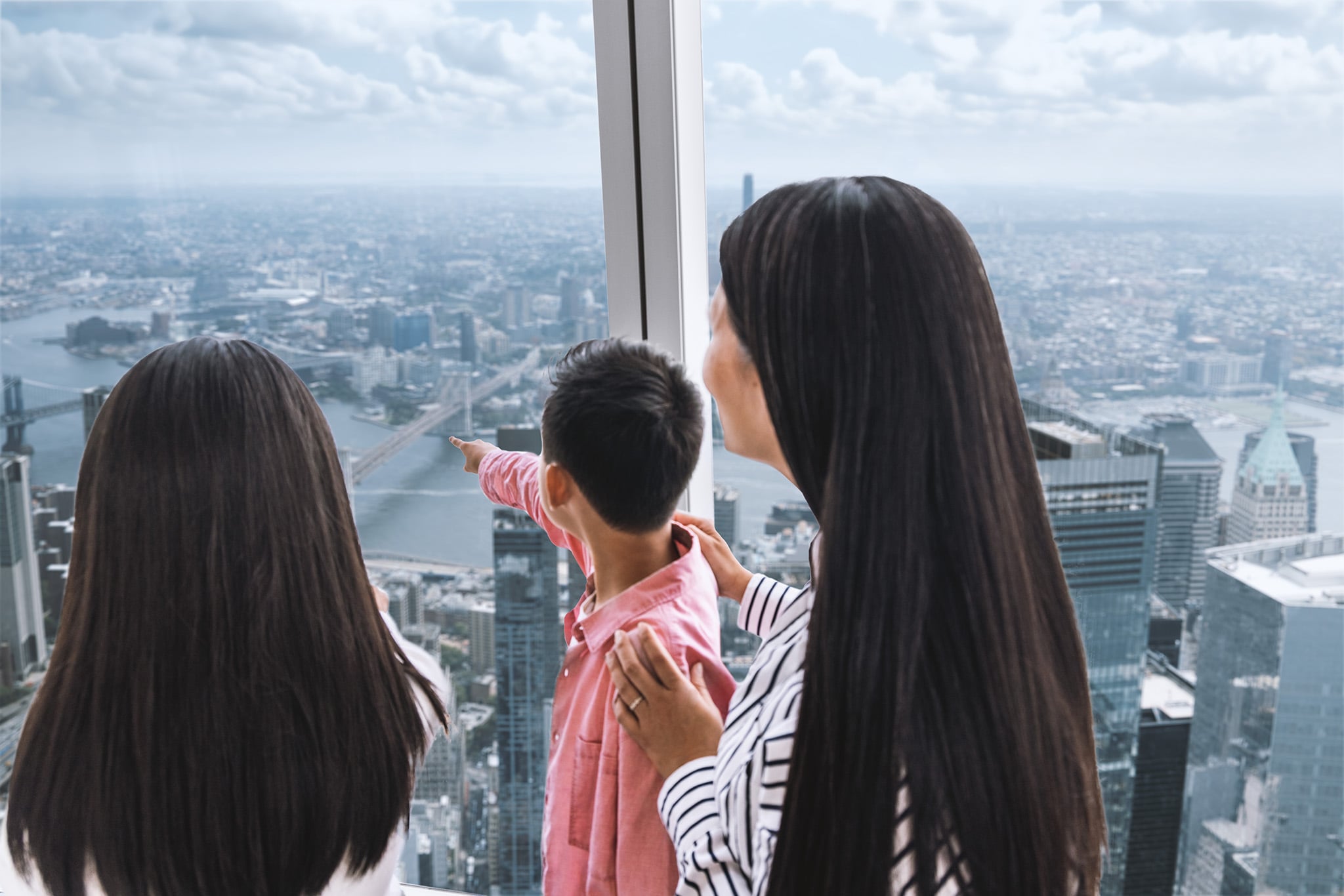 Family viewing the New York skyline from One World Observatory