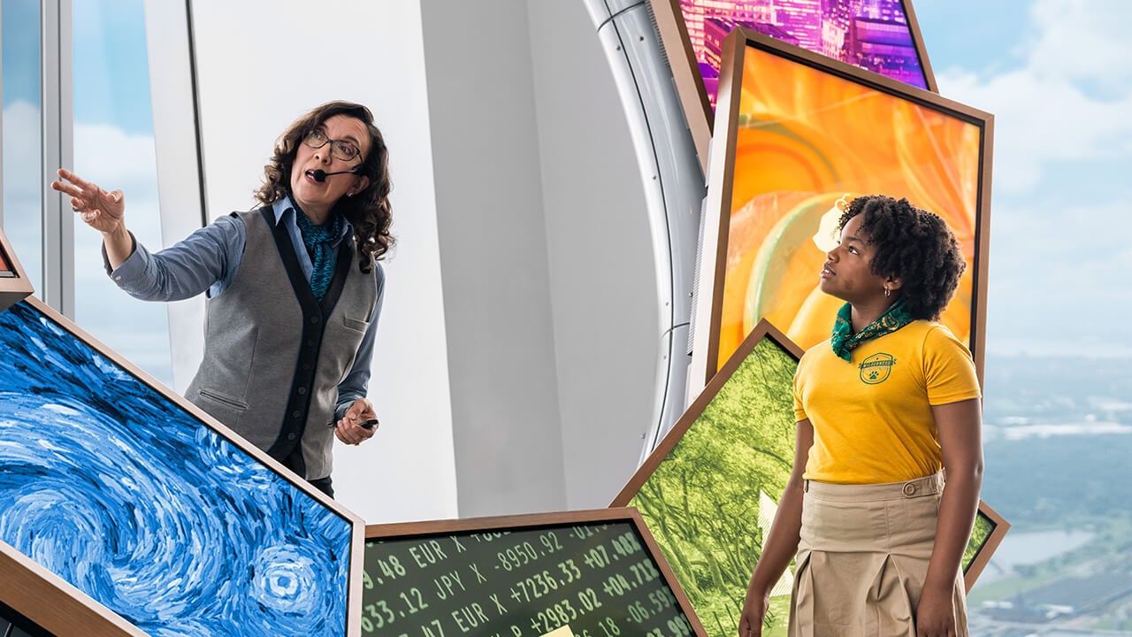 A guide introduces an interactive exhibit to a visitor