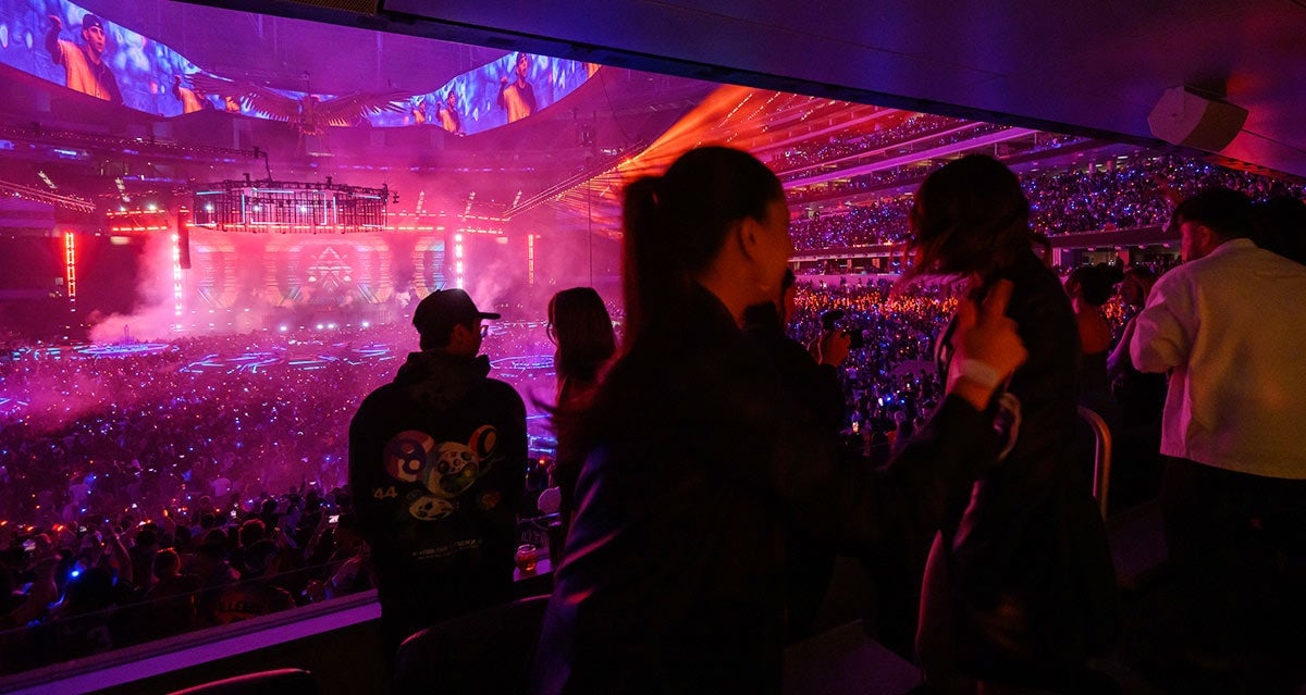 Guests watching an event from a SoFi Stadium suite