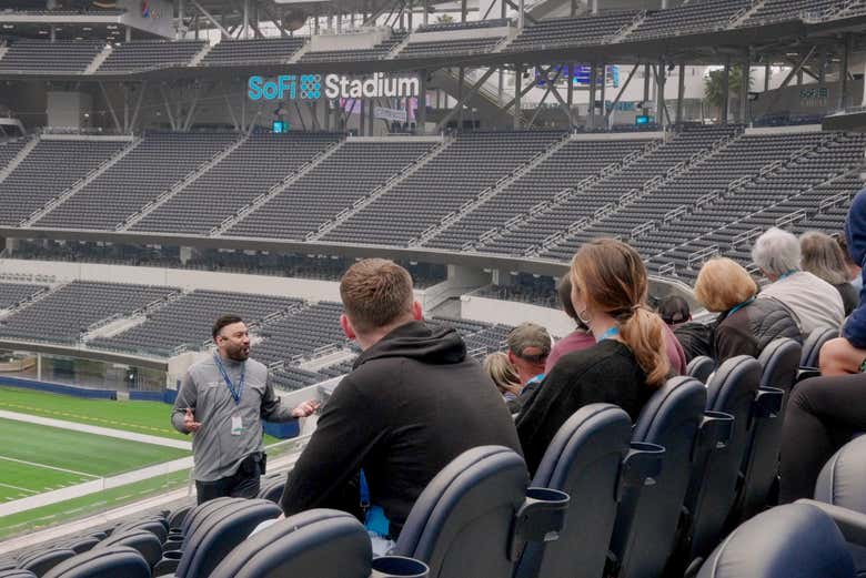 A guide speaking to tour visitors in the stadium seating