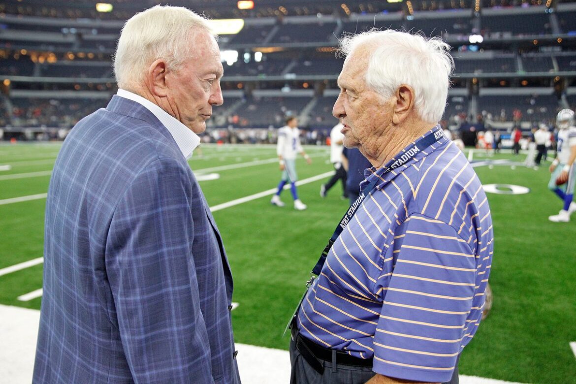 Jerry Jones speaking with Gil Brandt on a football field