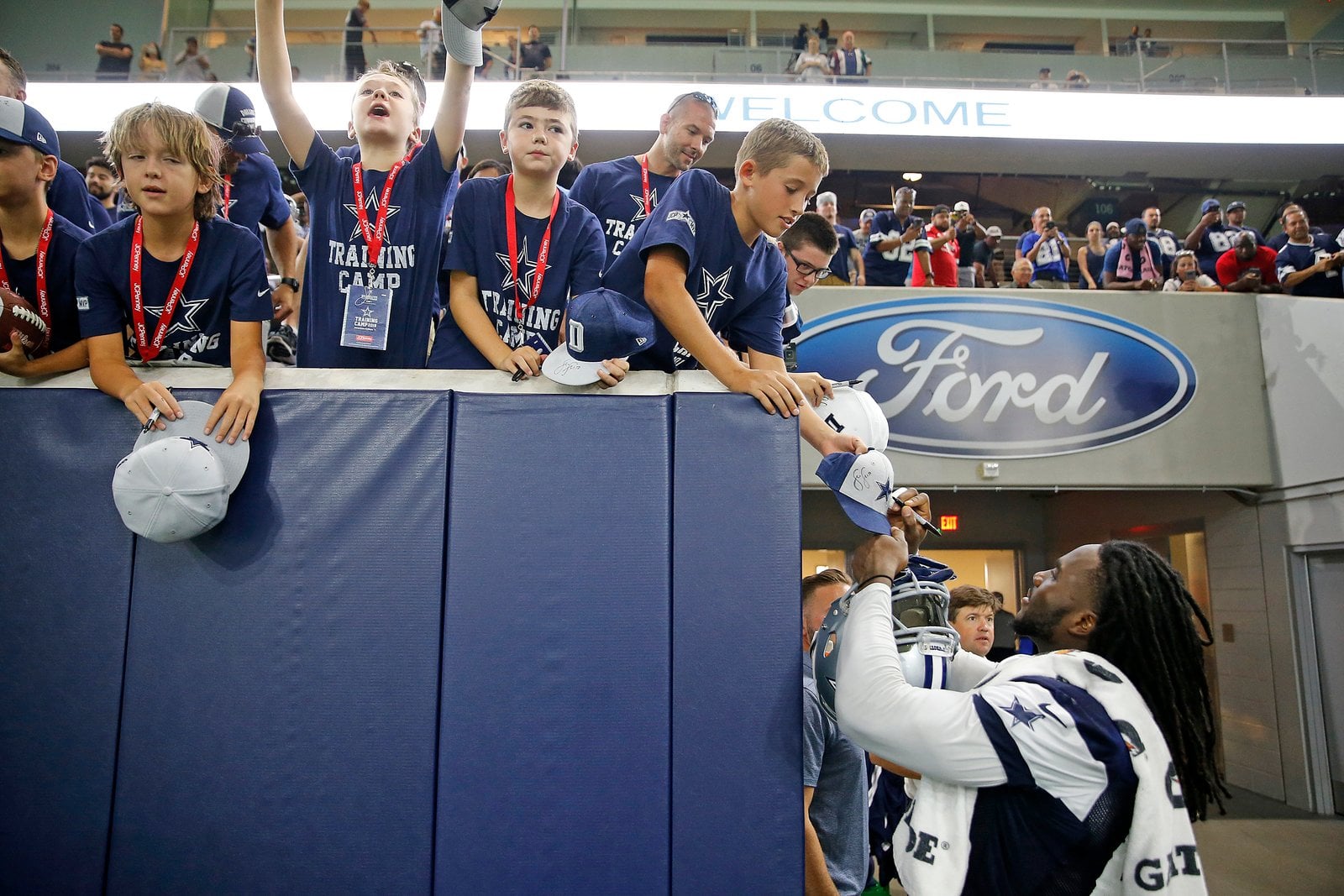 Cowboys player greeting young fans at a training camp event